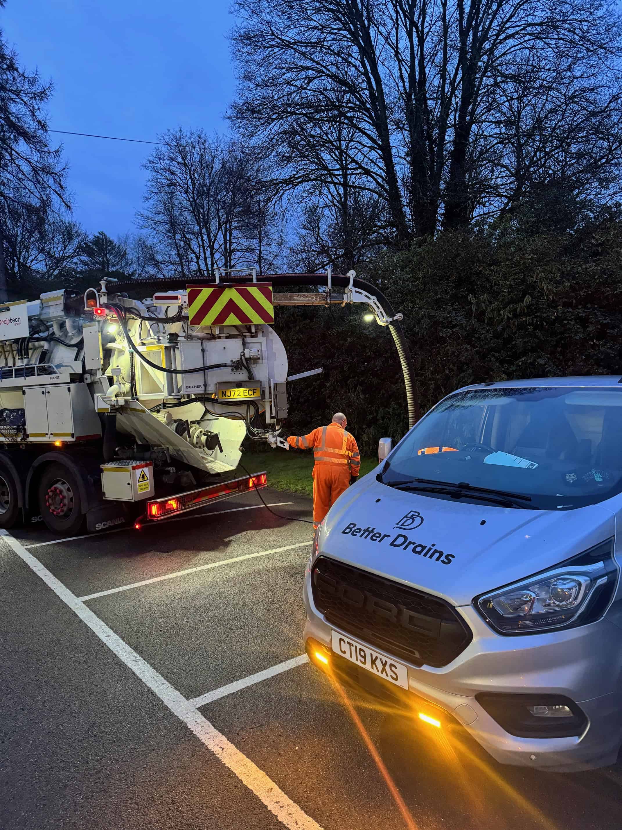 Drainage maintenance vehicle working on road with a drain cleaning machine.
